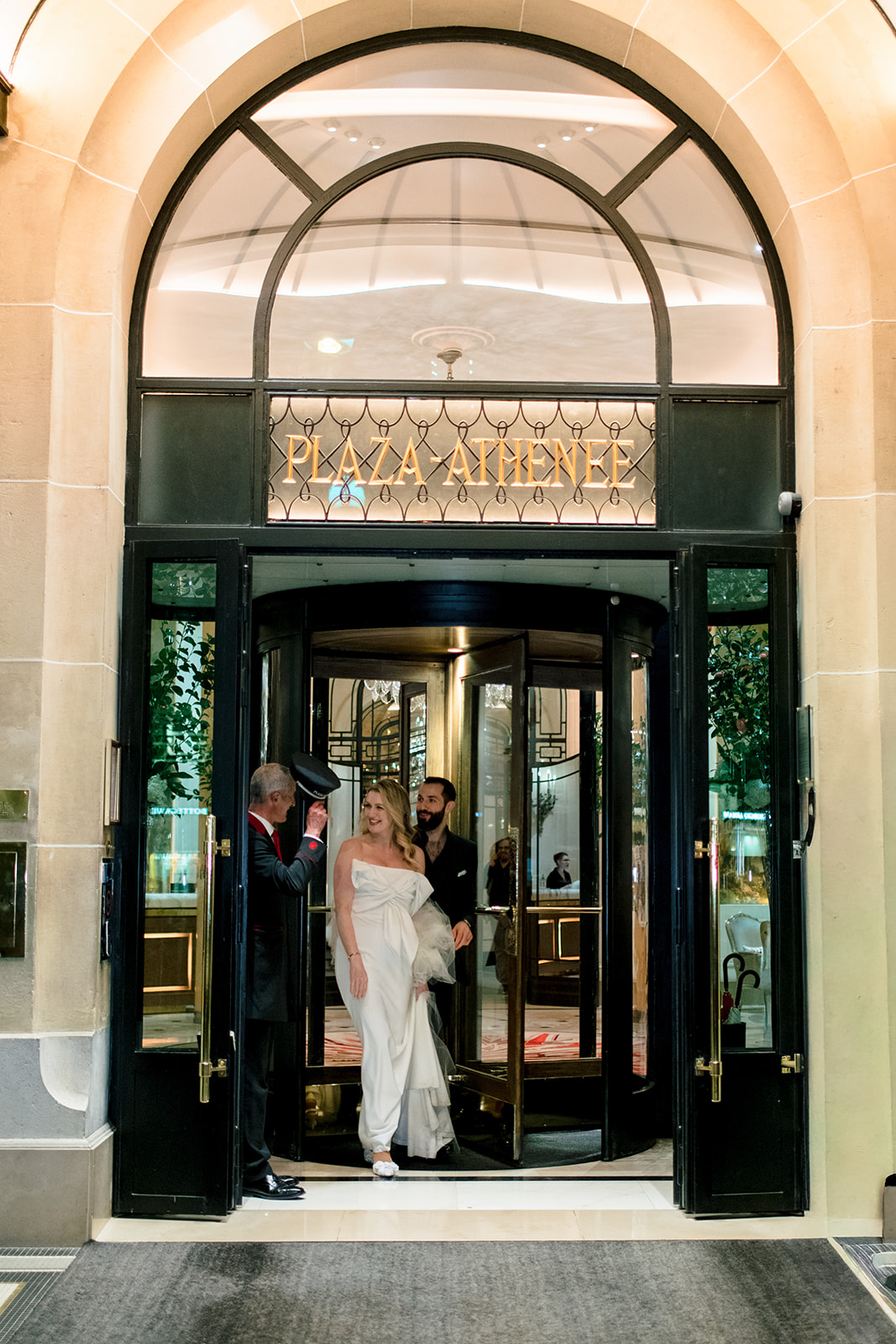 Newlyweds framed by the illuminated entrance of Hôtel Plaza Athénée Paris
